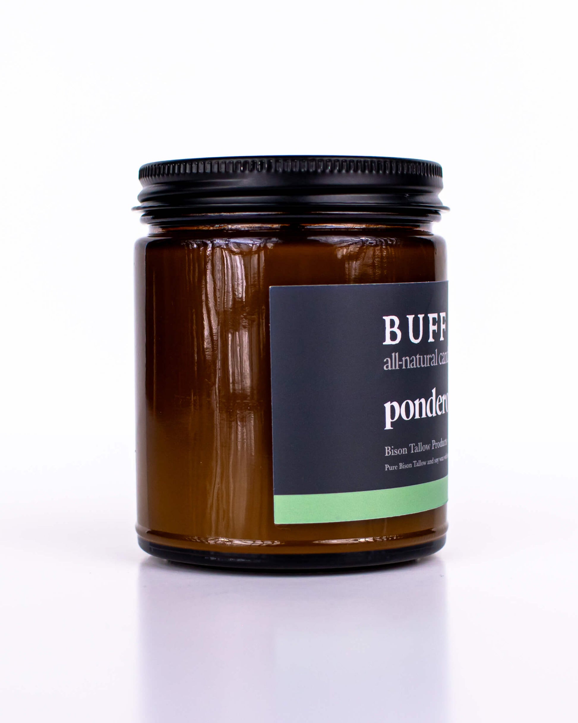 Buff Bar All-natural candle in a amber glass with black lid and label featuring the Ponderosa Pine fragrance and the Buff Bar Bison illustration. The candle is on a white background.