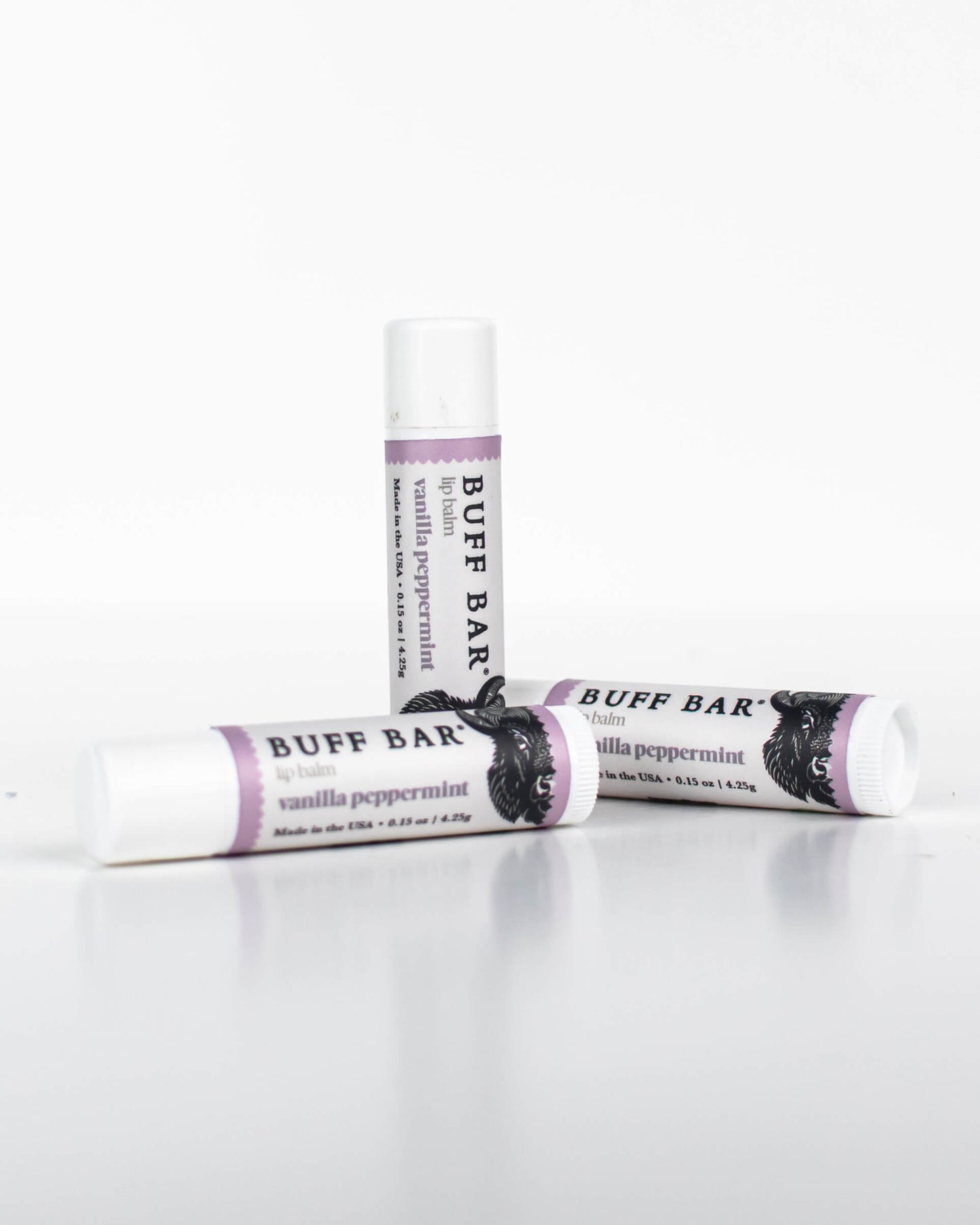Three tubes of Buff Bar All-Natural lip balm featuring the Vanilla Peppermint Fragrance on a white background.