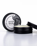 Buff Bar All-natural beard balm in a black tin with black lid and label featuring the Spice Barrell fragrance and the Buff Bar Bison illustration. The balm is on a white background.