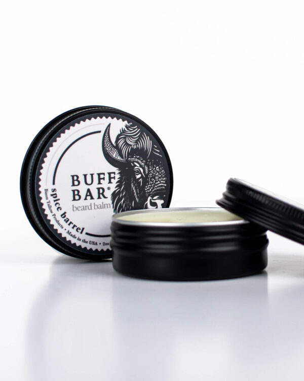 Buff Bar All-natural beard balm in a black tin with black lid and label featuring the Spice Barrell fragrance and the Buff Bar Bison illustration. The balm is on a white background.