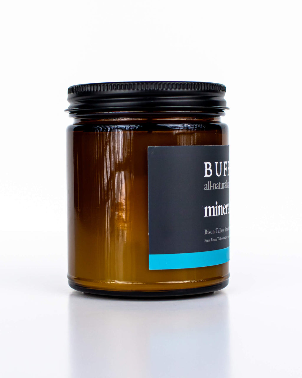 Buff Bar All-natural candle in a amber glass with black lid and label featuring the Mineral Pool fragrance and the Buff Bar Bison illustration. The candle is on a white background.