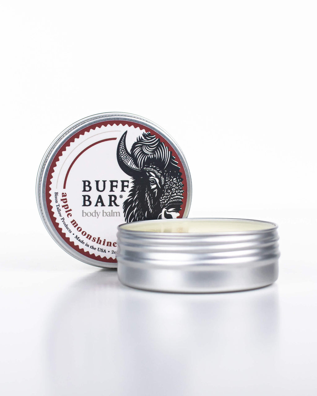 Buff Bar All-natural body balm in a tin and label featuring the Apple Moonshine fragrance and the Buff Bar Bison illustration. The tin is on a white background.