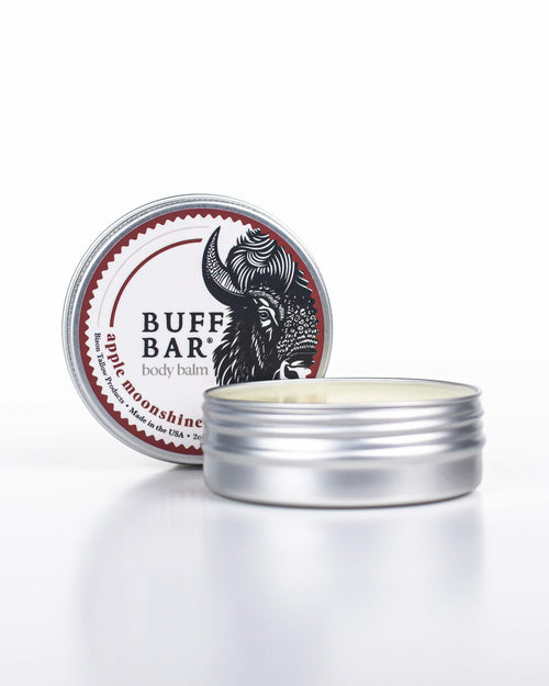 Buff Bar All-natural body balm in a tin and label featuring the Apple Moonshine fragrance and the Buff Bar Bison illustration. The tin is on a white background.