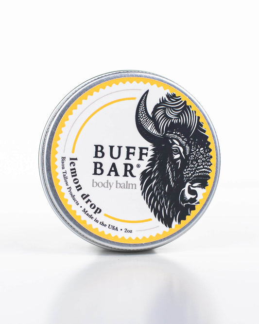 Buff Bar All-natural body balm in a tin and label featuring the Lemon Drop fragrance and the Buff Bar Bison illustration. The tin is on a white background.