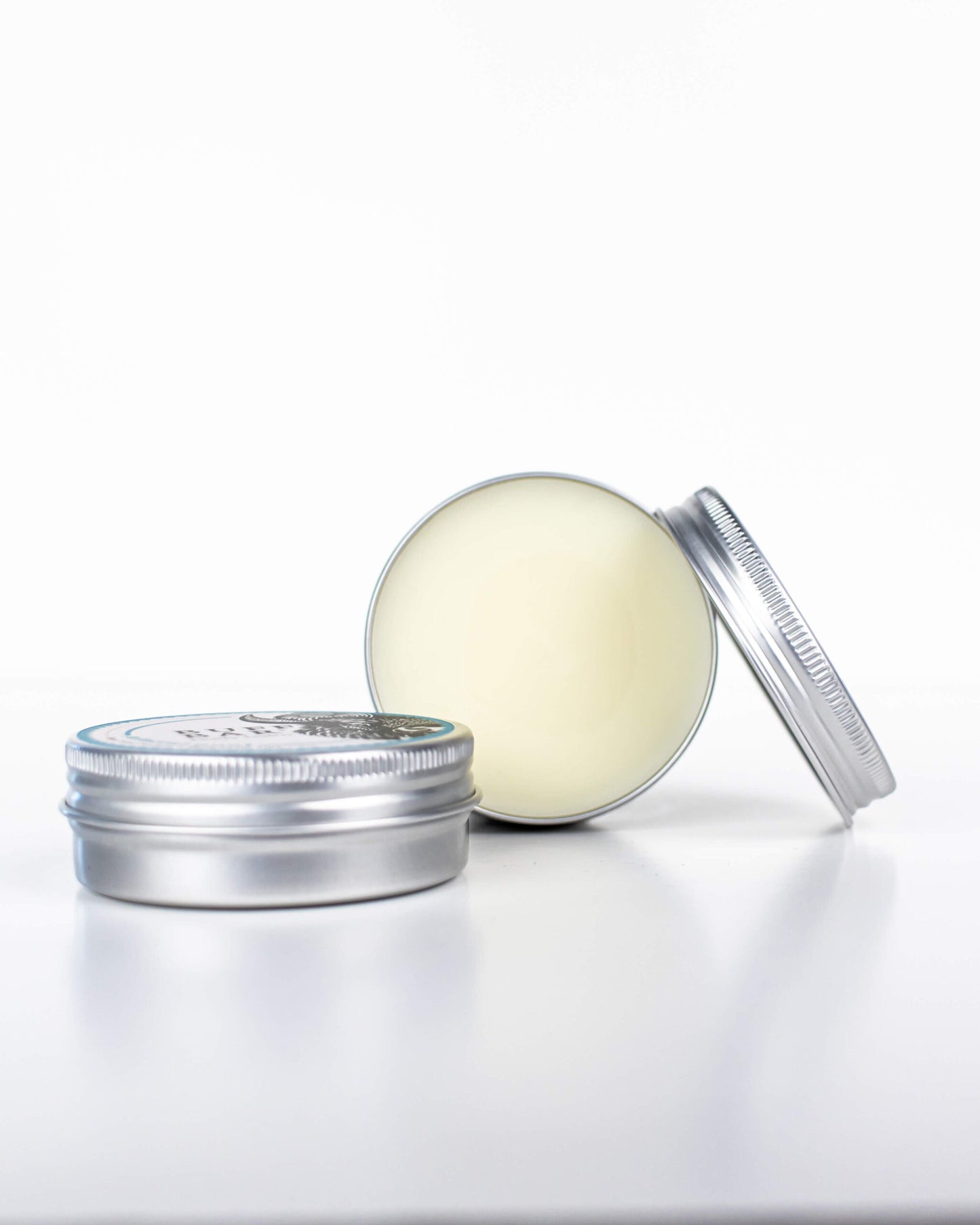 Buff Bar All-natural body balm in a tin and label featuring the Mineral Pool fragrance and the Buff Bar Bison illustration. The tin is on a white background.