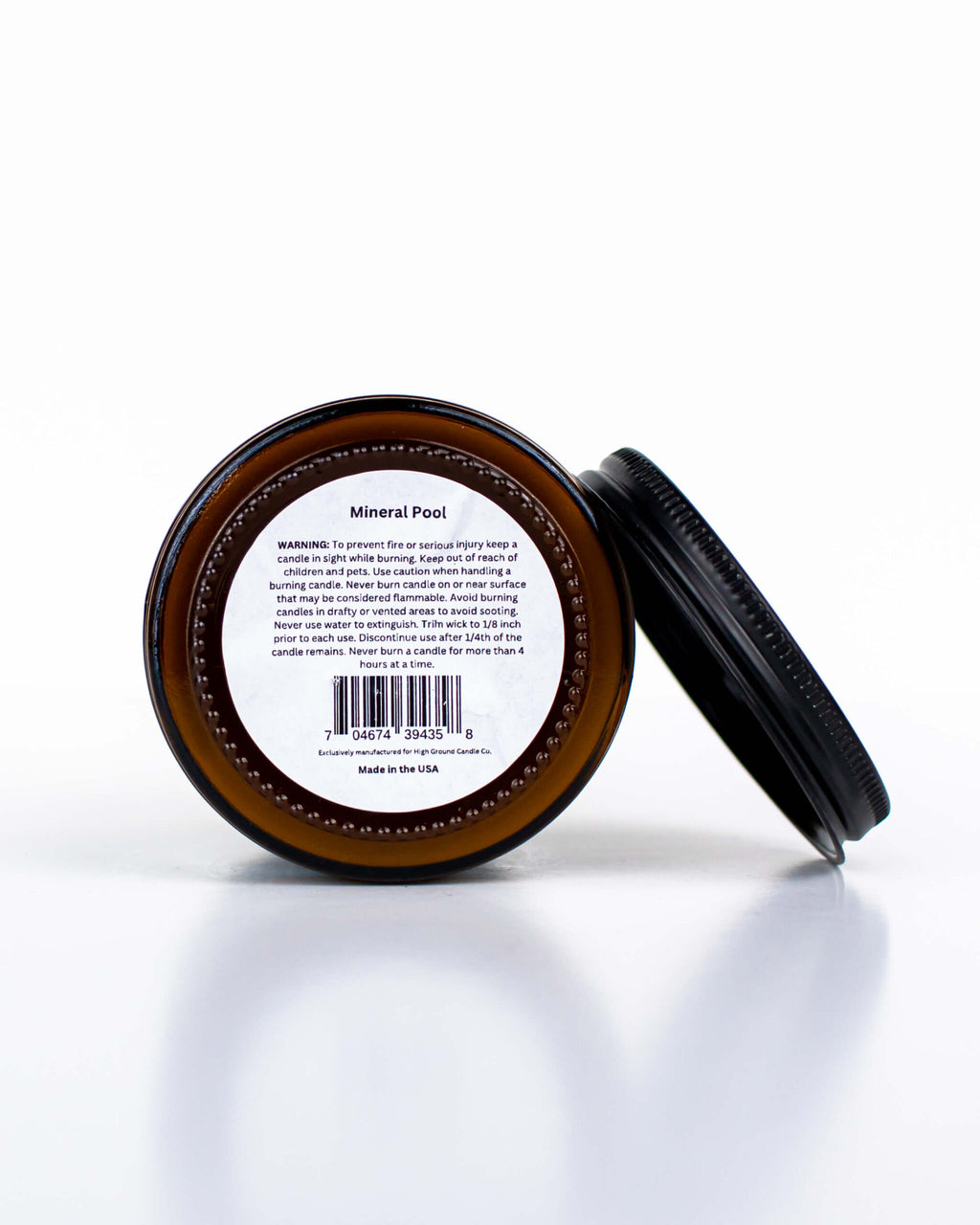 Buff Bar All-natural candle in a amber glass with black lid and warning label featuring the Mineral Pool fragrance. The candle is on a white background.